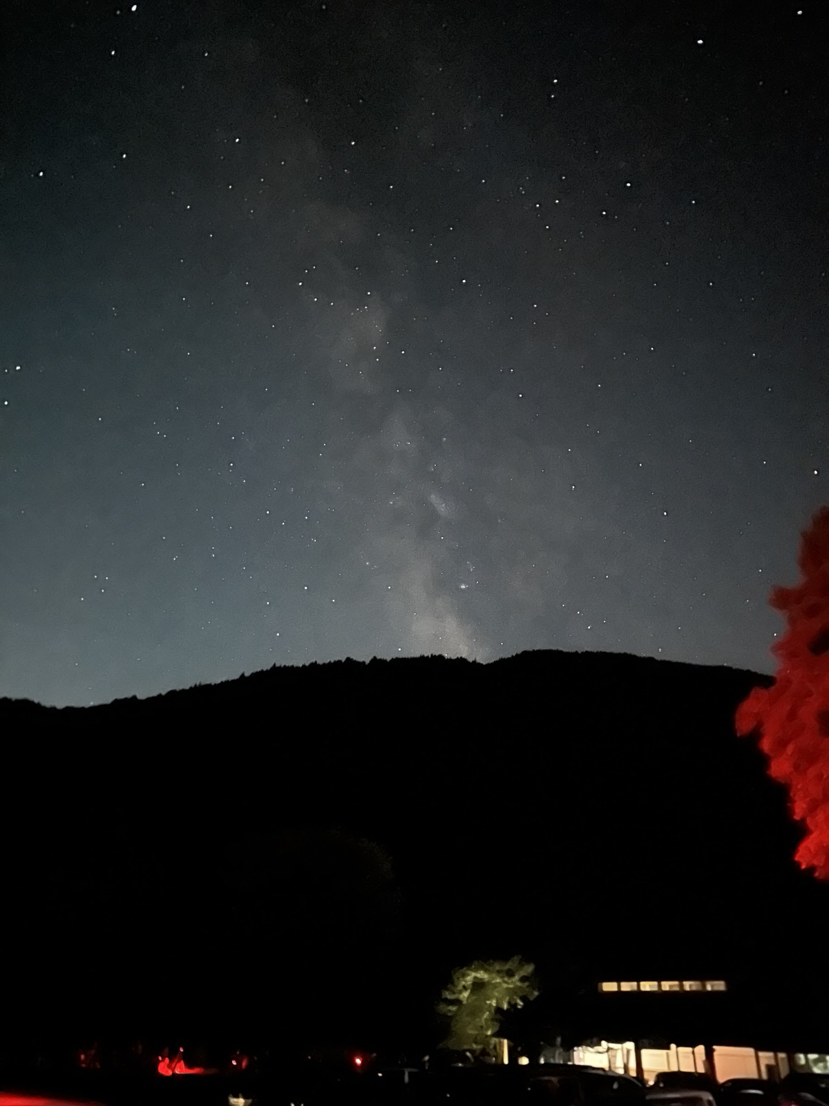 街あかりの上に広がる天の川を縦位置で撮った写真