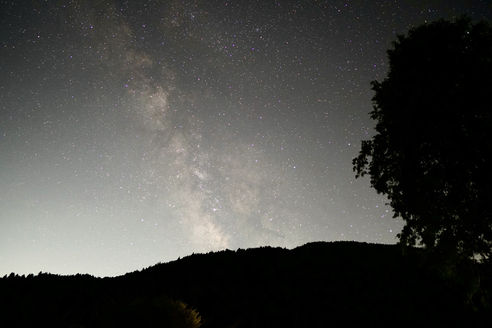 山の稜線から立ち上がる天の川の写真