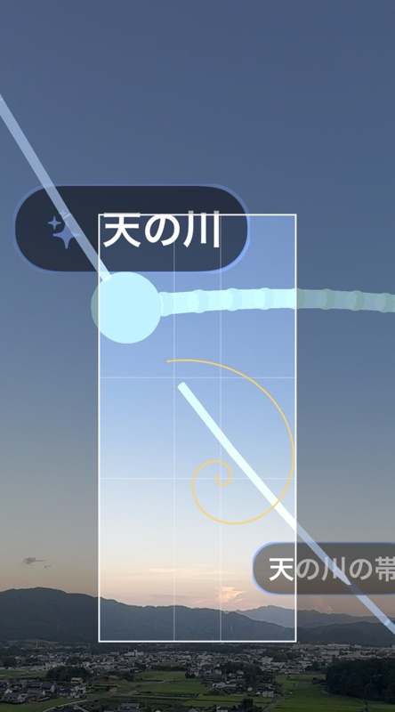 夕暮れの田園風景に天の川のマーカーと帯が重なるAR画面