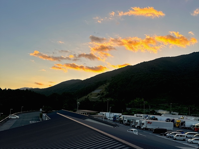 山の稜線の上に焼けた雲が浮かぶ写真